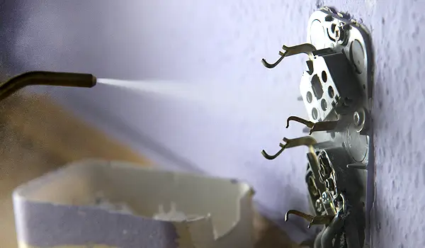 Poloskairtás: Porozószeres kezelés Rovarirtó porozószert fújnak a megbontott konnektorra.